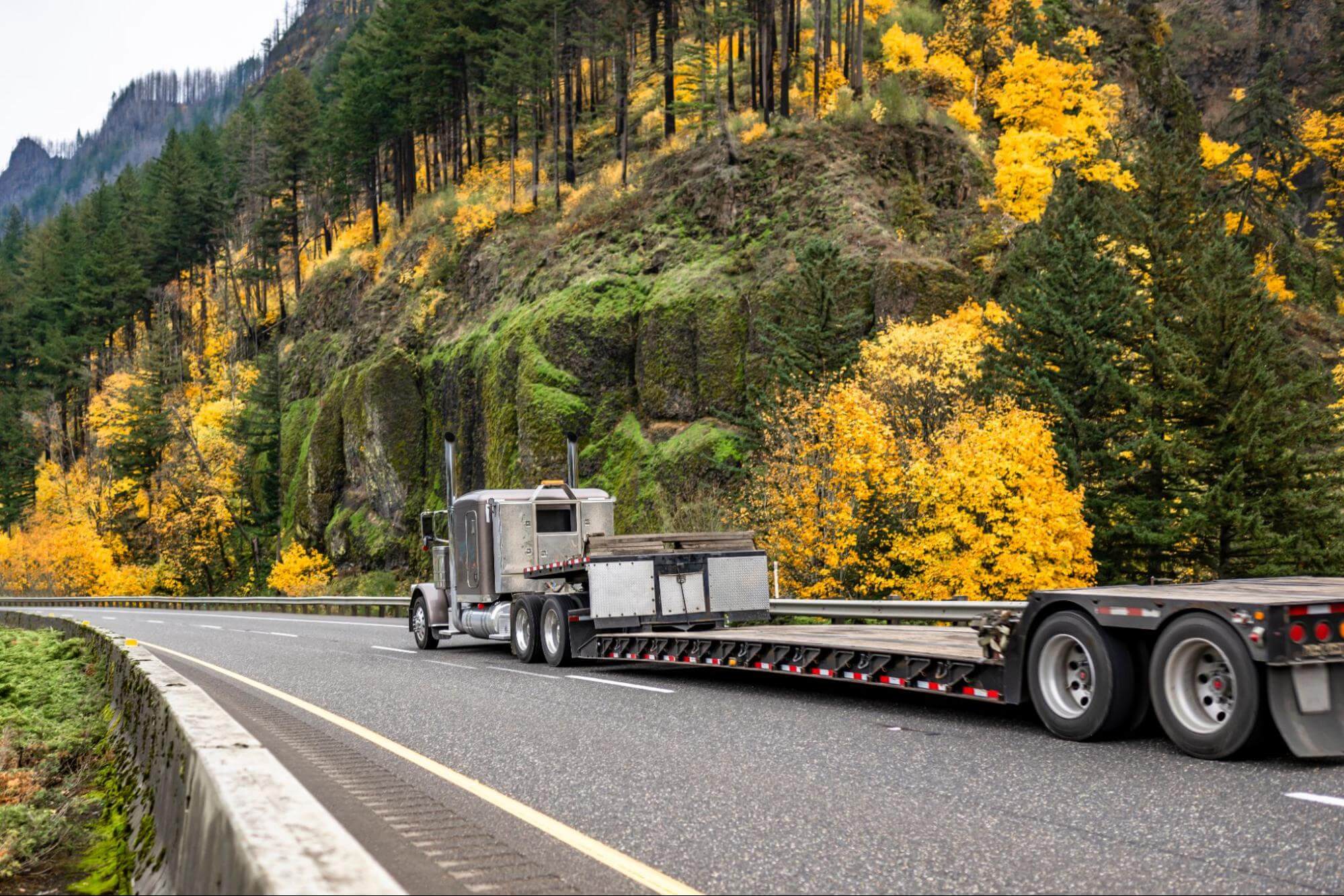 a step deck trailer on a mountain road